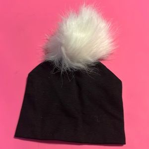 Black hat with white faux fur pom